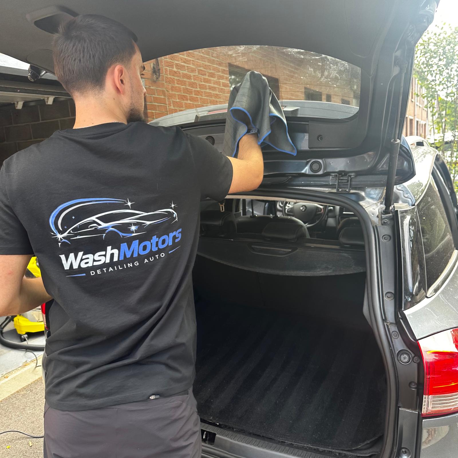 Matys, artisan WashMotors, en train de nettoyer le coffre d'un véhicule à domicile